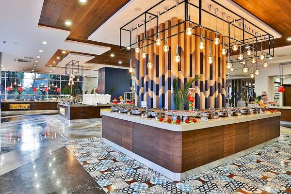Buffet-Bereich im Saturn Palace Resort mit farbenfrohem Dekor und verschiedenen Speisen.