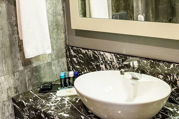 Badezimmer im Saturn Palace Resort mit weißem Waschbecken und Marmorplatte.