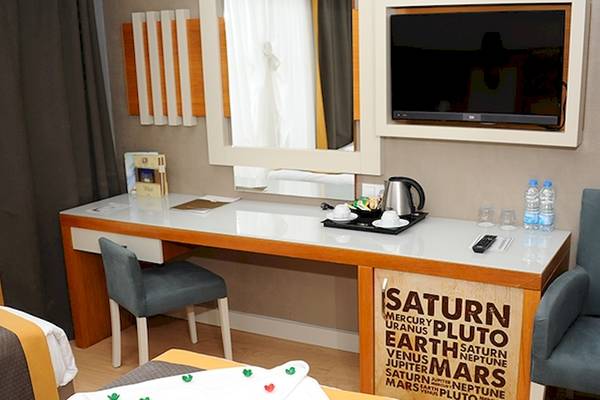 Hotelzimmer im Saturn Palace Resort mit Schreibtisch, Fernseher und Wasserflaschen