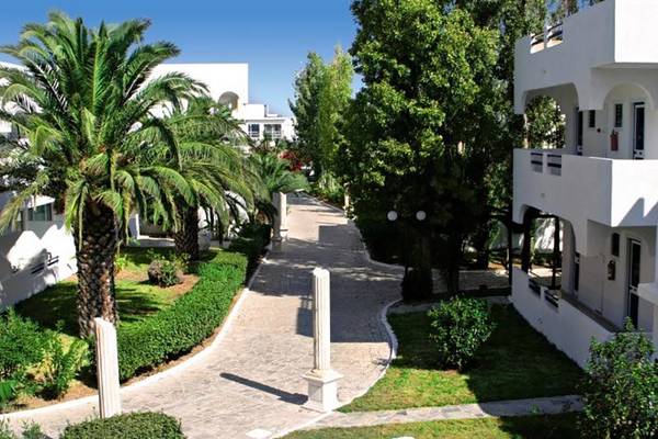 Eingangsbereich des Smy Kos Beach & Splash Hotels mit Palmen und weißen Gebäuden.