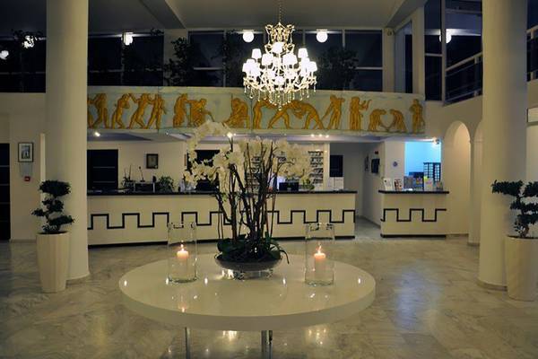 Lobby des Smy Kos Beach & Splash Hotels mit zentralem Tisch, Blumenarrangement und Kerzen.