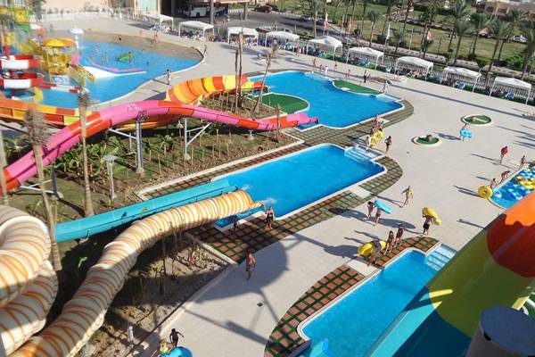 Ein Wasserpark von oben gesehen mit verschiedenen Wasserrutschen und Pools, viele Besucher sind im Bild.