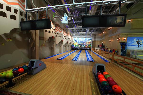 Bowlingbahn im Ali Baba Palace Hotel mit bunten Bowlingkugeln und Dekoration.