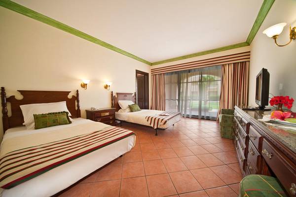 Zweibettzimmer im Ali Baba Palace mit zwei Betten, Fernseher, und Dekor.