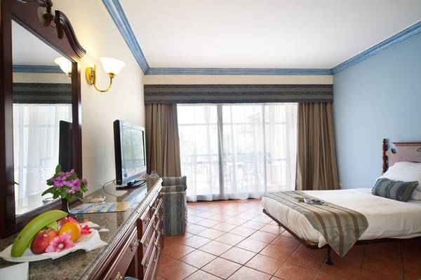 Zimmer im Ali Baba Palace Hotel mit Bett, Fernseher und Obst auf dem Tisch.