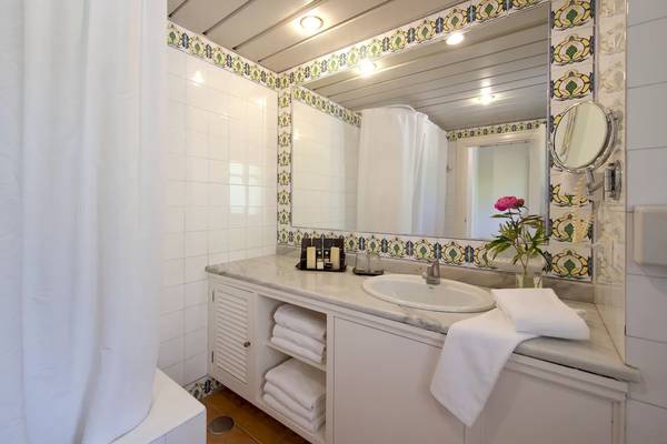 Badezimmer im Bluebay Banus Hotel mit weißem Waschbecken und gefalteten Handtüchern.