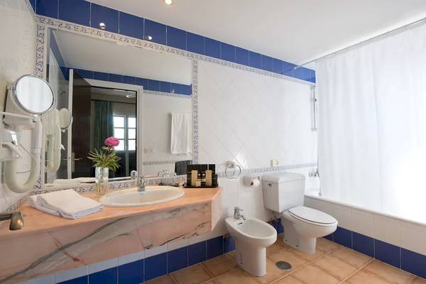 Badezimmer im Bluebay Banus Hotel mit Waschbecken, Bidet, Toilette und Badewanne.