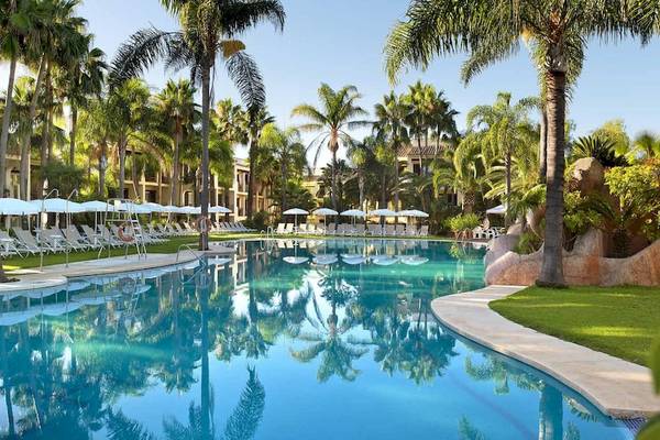 Außenpool des Bluebay Banus Hotels mit vielen Sonnenliegen und Palmen
