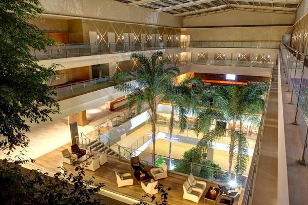Innenansicht der Lobby des Rixos Premium Dubrovnik Hotels mit Palmen und Sitzmöbeln