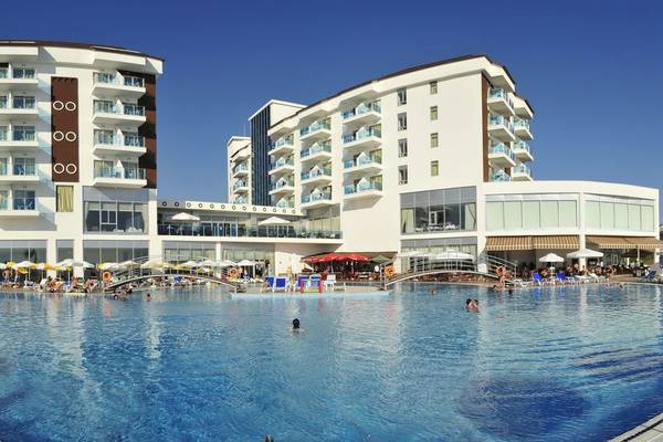 Außenbereich des Cenger Beach Resort & Spa mit großem Pool und Sonnenschirmen.