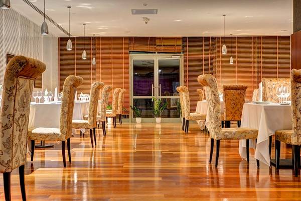 Innenansicht des Restaurants im Rixos Premium Dubrovnik mit gedeckten Tischen und blumigen Stühlen.