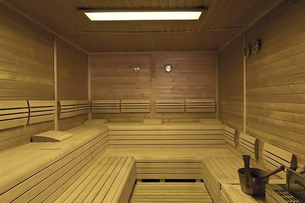 Holzsauna im Rixos Premium Dubrovnik mit gepolsterten Bänken und Metalleimer