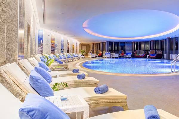Innenpoolbereich des Rixos Premium Dubrovnik mit Lounge-Sesseln und blauen Kissen.