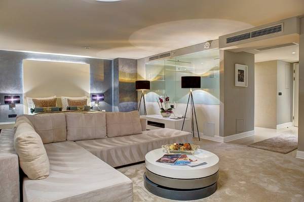 Luxuriöses Hotelzimmer mit großem Sofa, Tisch und Bett