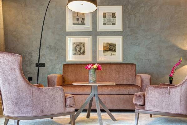Loungebereich im Rixos Premium Dubrovnik mit einem Sofa, einem Tisch und zwei Sesseln.