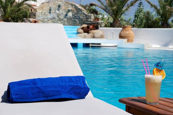Loungestuhl am Pool mit Getränk und Handtuch von Kamari Hotel