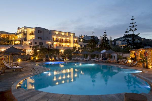 Kamari Hotel Pool bei Nacht mit beleuchtetem Gebäude und Loungeliegen