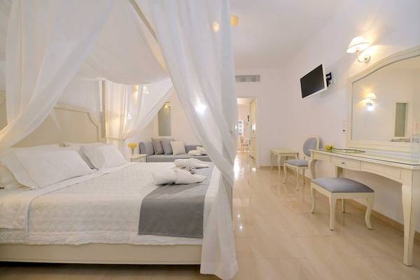 Schlafzimmer im Kamari Hotel mit weißem Himmelbett, Bettwäsche und Dekor