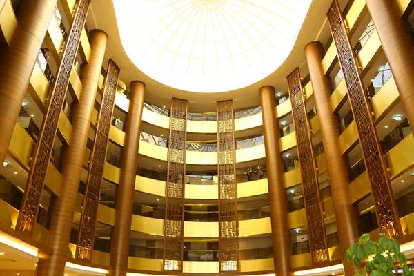 Innenansicht des Sunmelia Beach Resort Hotel & Spa mit hoher Lobby und mehreren Stockwerken.