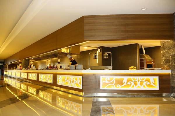 Innenansicht des Restaurants im Sunmelia Beach Resort Hotel & Spa mit gemusterten Fronten und reflektierten Lichtern.