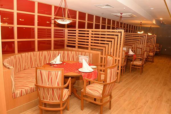 Innenbereich eines Restaurants im Sunmelia Beach Resort Hotel & Spa mit roten Wänden und Holzmöbeln.