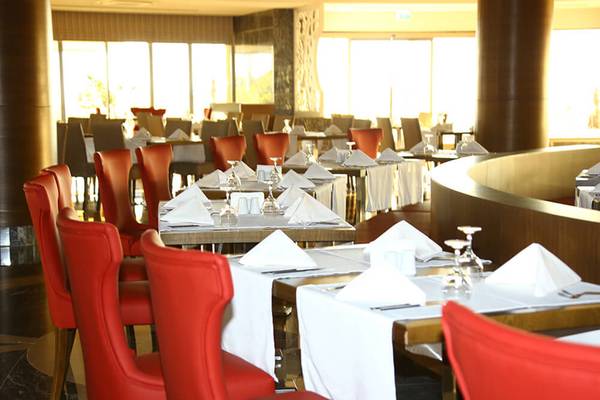 Restaurant im Sunmelia Beach Resort Hotel & Spa mit roten Stühlen und gedeckten Tischen.
