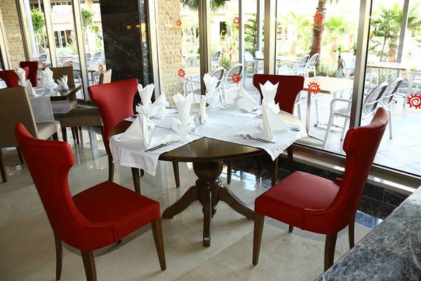 Restauranttisch im Sunmelia Beach Resort Hotel & Spa mit roter Tischdecke und Servietten.