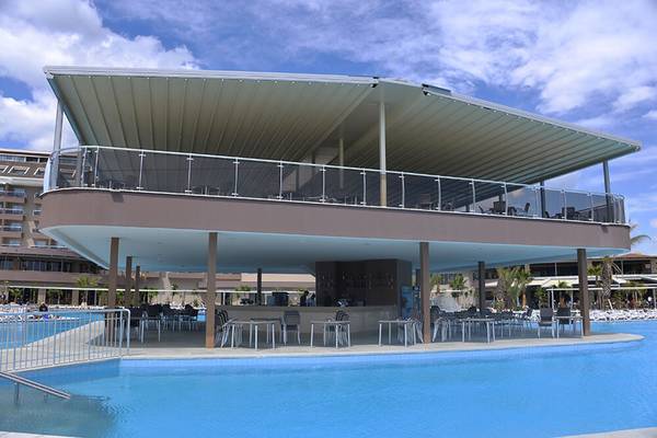 Pool-Bar des Sunmelia Beach Resort Hotel & Spa mit blauem Pool und Sonnenschirmen.