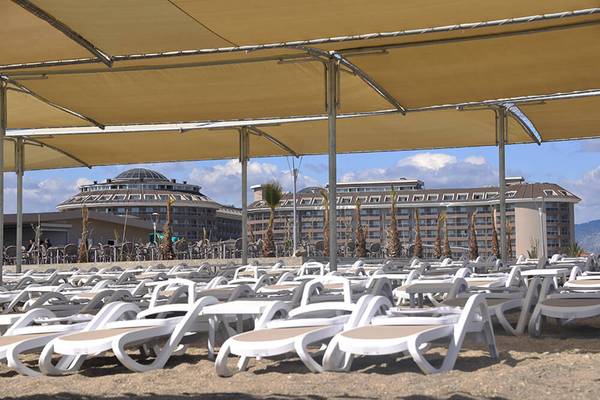Strand mit weißen Sonnenliegen und Sonnenschirmen vor dem Sunmelia Beach Resort Hotel & Spa