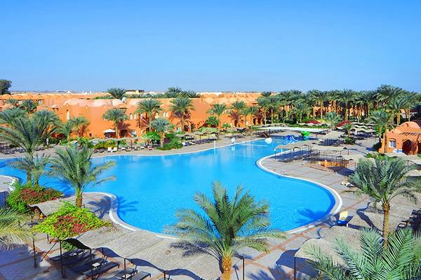 Luftaufnahme des Jaz Makadi Oasis Resort & Club mit großem Swimmingpool und umgeben von Palmen und Sonnenliegen.