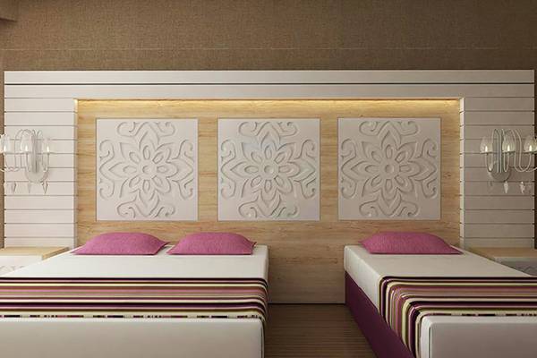 Doppelbett-Zimmer im Sunmelia Beach Resort Hotel & Spa mit dekorativen Wandpaneelen und Nachttischen.