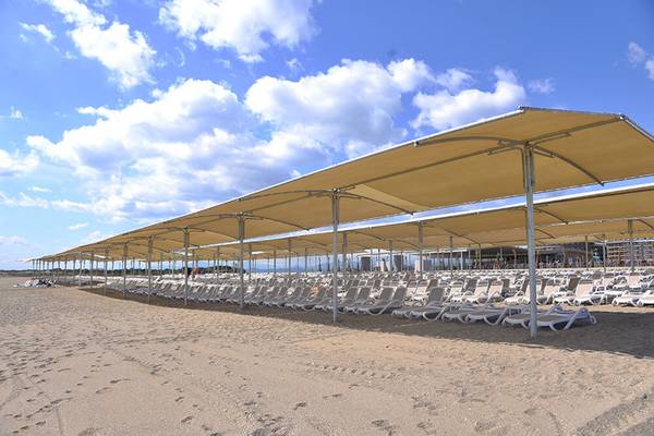 Reihen von Sonnenliegen unter Sonnenschutz am Strand des Sunmelia Beach Resort Hotel & Spa