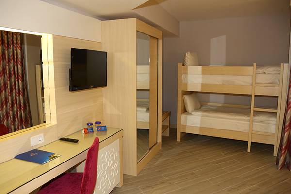 Ein Hotelzimmer mit Doppelstockbett und Schreibtisch, neben einer großen Spiegelwand.
