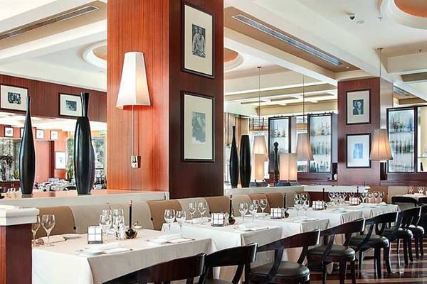 Innenansicht des Restaurants im Hilton Dubai Jumeirah Resort mit gedeckten Tischen und eleganten Möbeln.