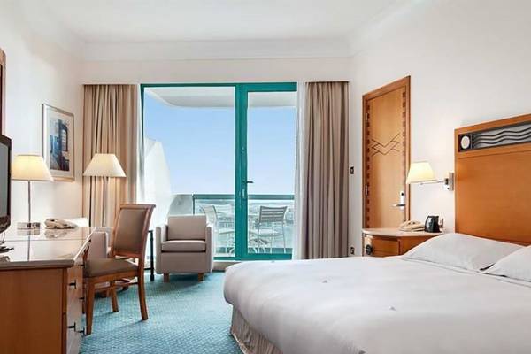 Hotelzimmer im Hilton Dubai Jumeirah Resort mit Blick auf das Meer und Möbeln.