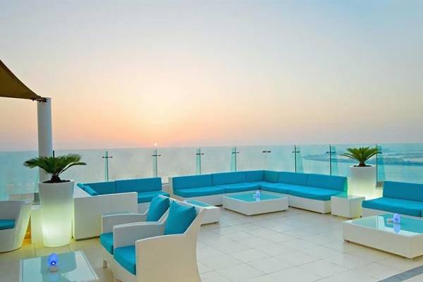 Terrasse des Hilton Dubai Jumeirah Resorts mit Blick auf den Sonnenuntergang am Meer