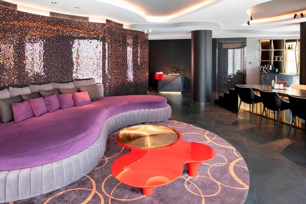Lobby-Lounge-Bereich des W Dubai - The Palm Hotels mit einer violetten Couch und einem roten Tisch.