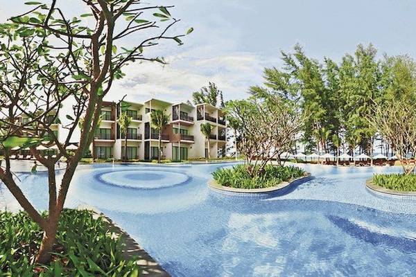 Außenpool des Holiday Inn Mai Khao Resorts mit umliegenden Bäumen und Gebäuden