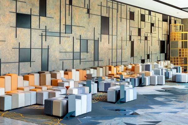Loungebereich im W Dubai - The Palm mit modularen Sofas und geometrischem Wanddesign.