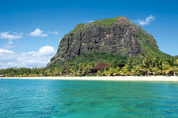 LUX Le Morne Hotel mit Strand und Felsformation im Hintergrund.