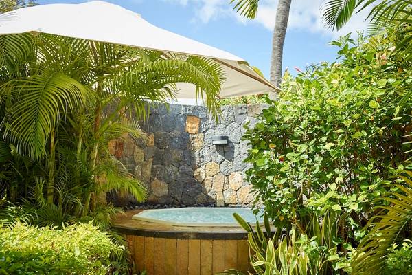 Outdoor Jacuzzi im LUX Le Morne Hotel, geschützt durch einen weißen Schirm