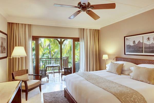 Hotelsuite von LUX Le Morne mit großem Bett, Balkon und Innendekoration.