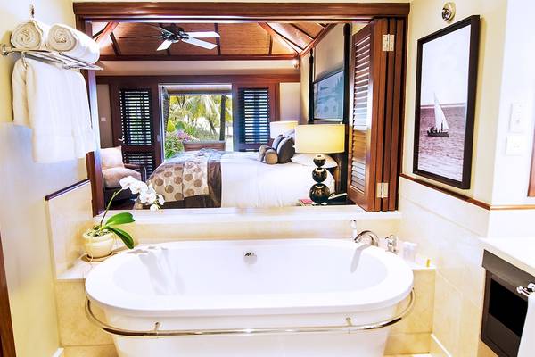Badezimmer im LUX Le Morne Hotel mit Whirlpool und Ausblick auf das Schlafzimmer