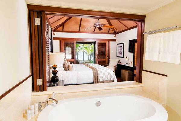 Suite im LUX Le Morne Hotel mit Badewanne und Blick auf das Bett