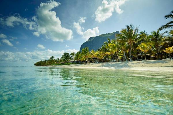 Strandansicht des LUX Le Morne Hotels mit kristallklarem Wasser und Palmen