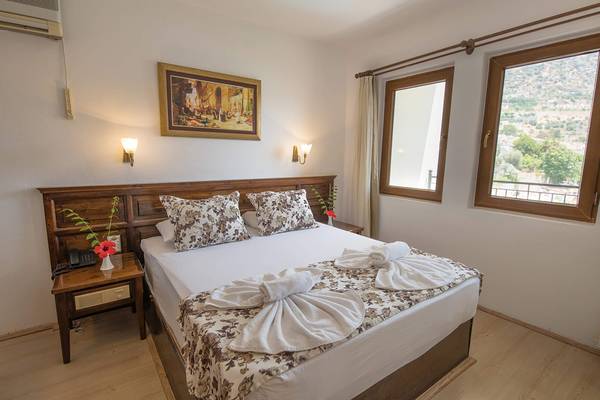 Schlafzimmer im Pirat Hotel mit Bett, Fenstern und Blick auf Berge