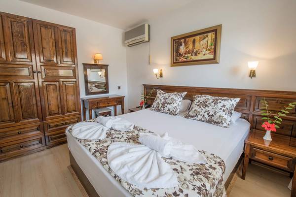Schlafzimmer im Pirat Hotel mit Doppelbett, Holzmöbeln und Klimaanlage.