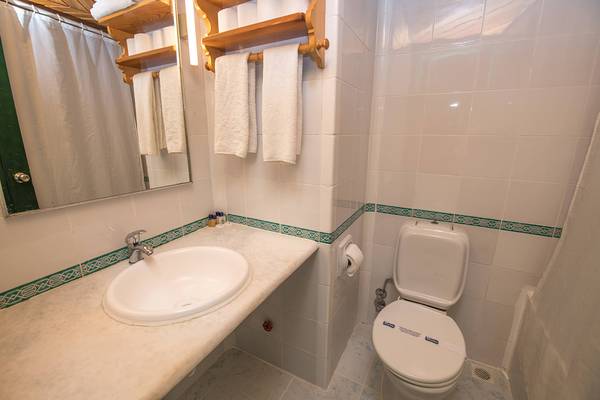 Badezimmer im Pirat Hotel mit Waschbecken, Toilette und Handtüchern