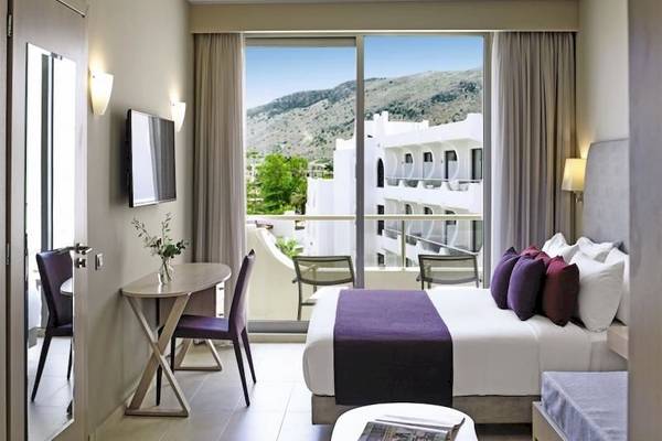 Innenansicht eines Zimmers im Atlantica Akti Zeus Hotel mit Blick auf die Berge.