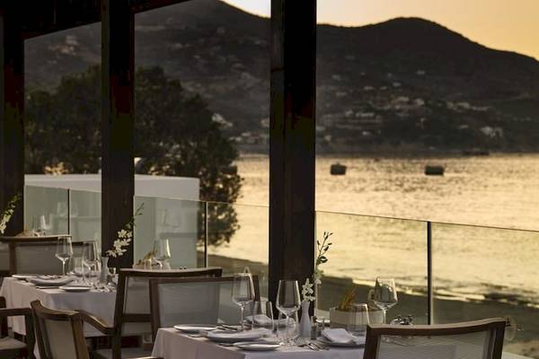 Restaurant mit Meerblick im Atlantica Akti Zeus Hotel, Tische und Stühle sind draußen aufgestellt.